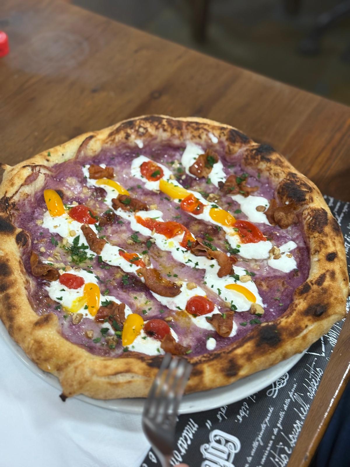 Pizza gourmet con cornicione alto e pomodorini colorati