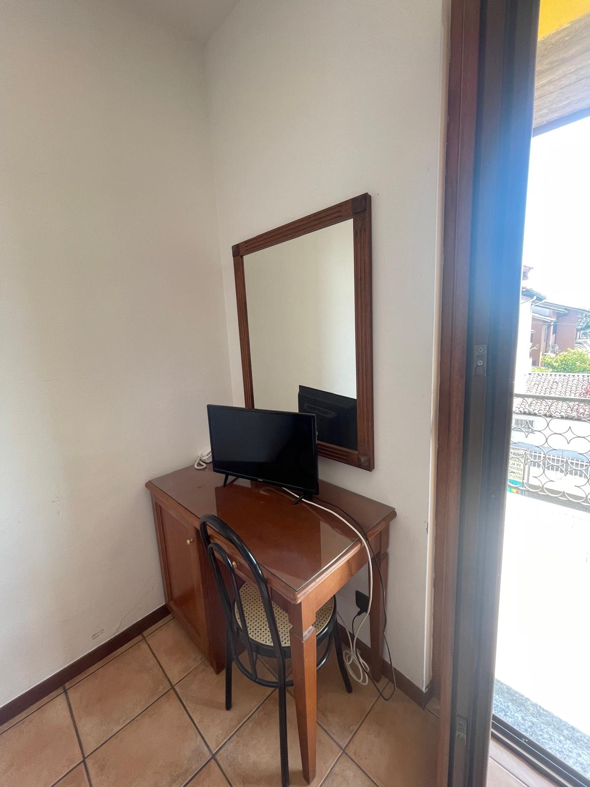 Scrivania, televisore e balcone in camera